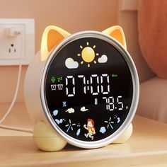 an alarm clock is sitting on a table next to a wall with a cat face