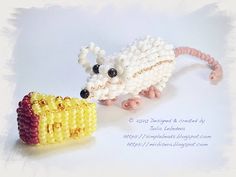 an animal made out of beads on top of a white sheet with writing underneath it