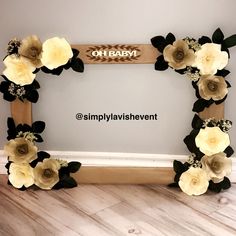 a photo frame decorated with flowers and black leaves for a baby's first birthday