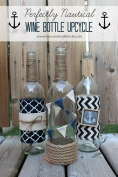 three glass bottles with twine and rope wrapped around them on a wooden table in front of a fence