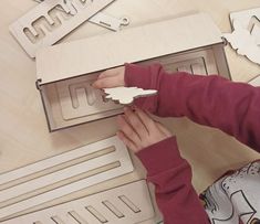 a person is working on some type of object with scissors and plywood board in the background