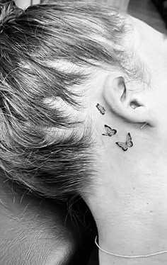 a person with a butterfly tattoo on their left side of the neck and behind her ear