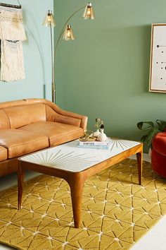 a living room with a couch, table and chair in it next to a rug