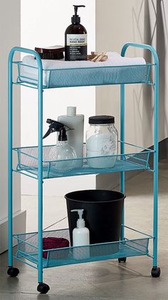 a bathroom cart with three shelves and soaps on the top, one shelf is blue