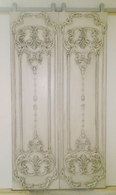 two white doors with ornate designs on them