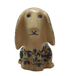 a ceramic figurine of a dog with blue flowers on it's body