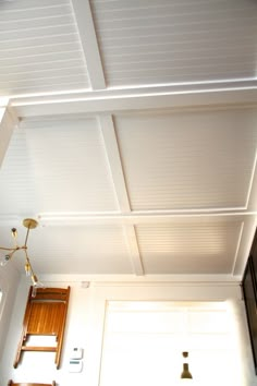 the ceiling is painted white and has wooden paneling on it, along with a light fixture