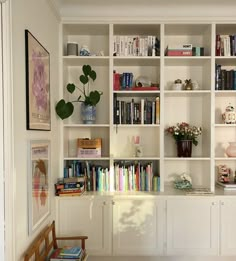 a bookshelf filled with lots of books next to a wall full of shelves