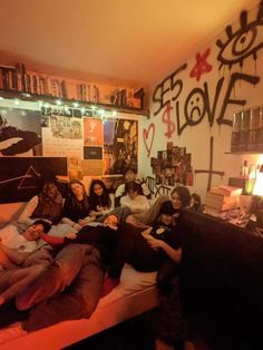 a group of people laying on top of a bed in a room filled with books