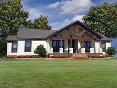 a white house sitting on top of a lush green field