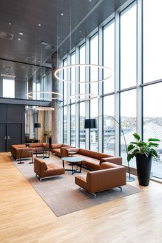 a large room with couches, tables and chairs in front of huge glass windows