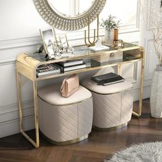 a vanity with two stools and a mirror on the wall in a white room