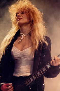 a woman with blonde hair holding a guitar