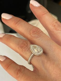 a woman's hand with a diamond ring on top of her finger and an engagement band