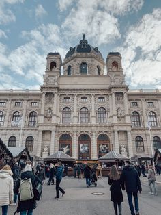 people are walking around in front of a large building