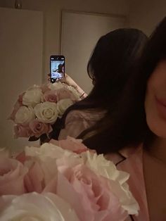 a woman taking a selfie with flowers in front of her