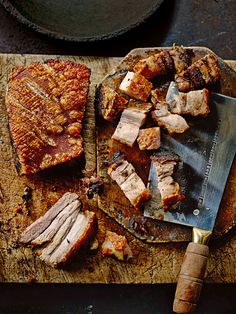 sliced meat on a cutting board next to a knife