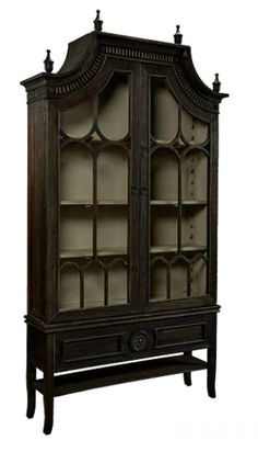 an old fashioned china cabinet with glass doors and carvings on the front, in dark wood