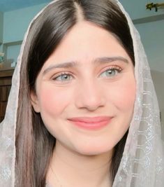 a woman wearing a veil and smiling at the camera