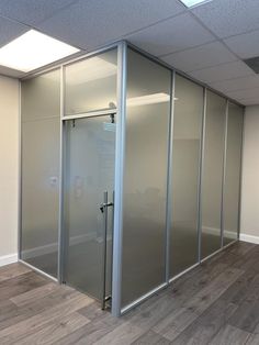 an empty room with glass walls and wood floors