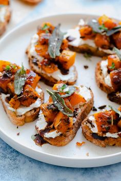 a white plate topped with slices of bread covered in toppings