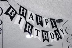 black and white happy birthday banner hanging from the ceiling