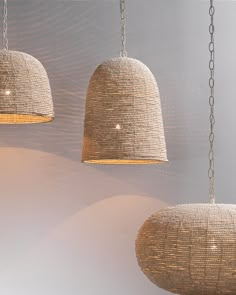 three light fixtures hanging from chains in a room