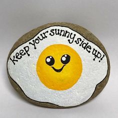 a rock with an egg painted on it that says keep your sunny side up,