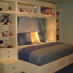 a bed with built in bookshelves above it and drawers underneath the headboard