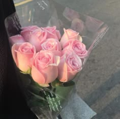 a bouquet of pink roses sitting on the back of a car