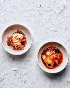 two bowls filled with food sitting on top of a white countertop next to each other