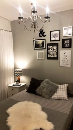 a bed room with a neatly made bed and pictures hanging on the wall above it