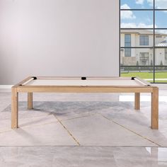 a pool table sitting in front of a large window