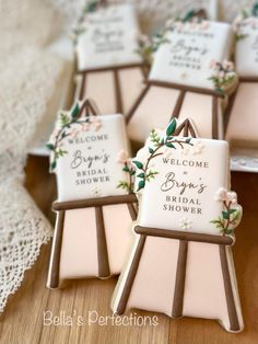 some cookies are sitting on a table with flowers and welcome signs in front of them