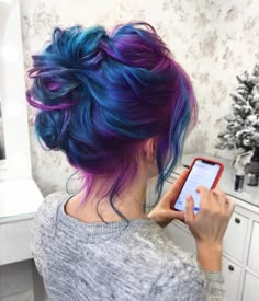 a woman with blue and purple hair using her cell phone