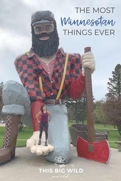 a giant statue of a man with a beard holding a shovel and standing next to a woman