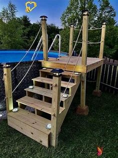 a wooden deck with steps leading up to a swimming pool