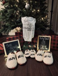 the baby's first christmas gift is being displayed in front of a christmas tree