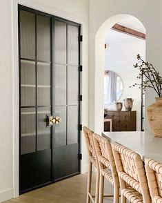 a dining room table and chairs in front of a black door