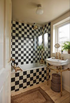 a bathroom with black and white tiles on the walls