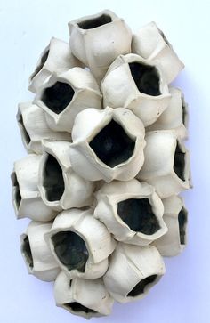 an odd looking object is made out of white and black clay, with holes in the middle