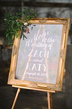 a wedding sign with greenery on it and a wooden easel holding the couple's vows