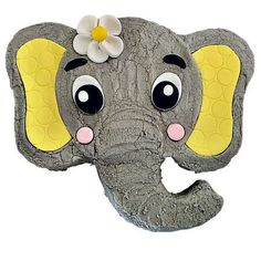 an elephant head with a flower on it's tusk and eyes painted yellow