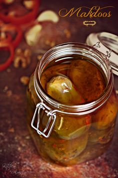 a jar filled with pickles sitting on top of a table next to some scissors