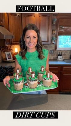 a woman holding a tray with cupcakes on it