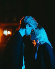 two people standing next to each other in the dark