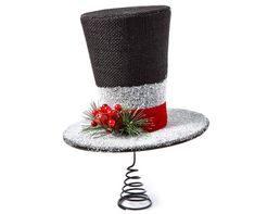 a black and white top hat with red berries on the rim is sitting on a metal stand