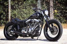 a black motorcycle parked in front of a chain link fence