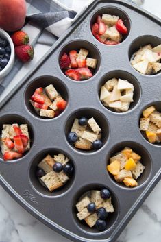 a muffin tin filled with fruit and crackers