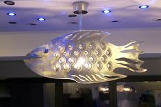 a fish shaped light fixture hanging from the ceiling